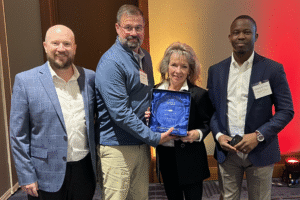 From left to right: Benjamin Halligan of Wells Fargo, Sam Van Scoyo of SCM, Tammy Ledbetter of SCM, and Dayo Olowoyeye of Wells Fargo celebrate SCM's successes in 2025.
